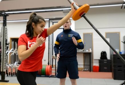 Girl being coached in a gym