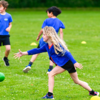 a girl throwing a ball outside