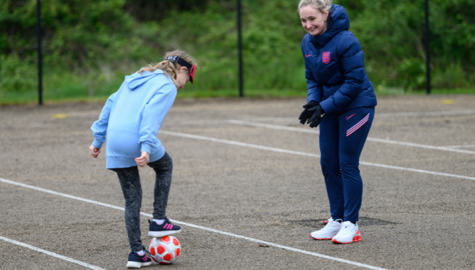 a female coach coaching a girl football