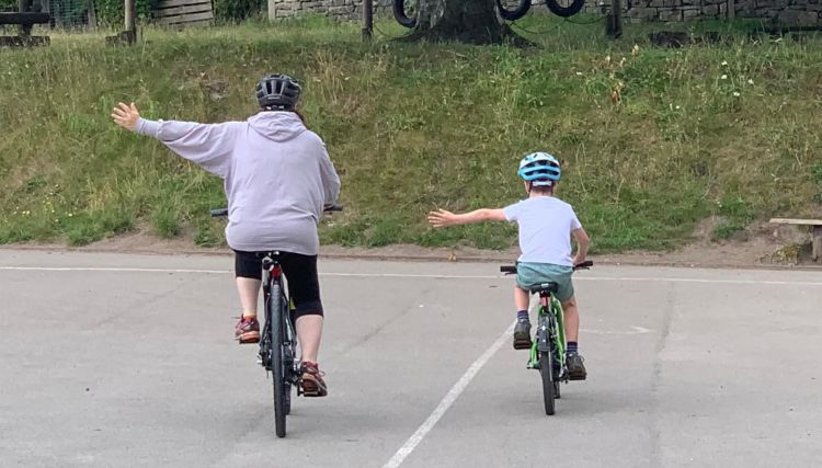 Adult and child cycling side by side