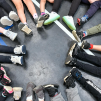 a group of children sat down in a circle - the image shows their feet and shoes