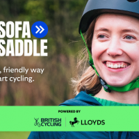 A girl wearing a cycling helmet smiling at the camera. Text reads: Soafa to Saddle and includes British Cycling and Lloyds logo