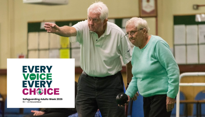 Two older adults taking part in an indoor bowls session, with one person pointing towards the rink while the other prepares to bowl. The image includes the Every Voice Every Choice Safeguarding Adults Week 2026 logo, highlighting the theme of inclusion, participation and supporting safe sporting environments for adults.