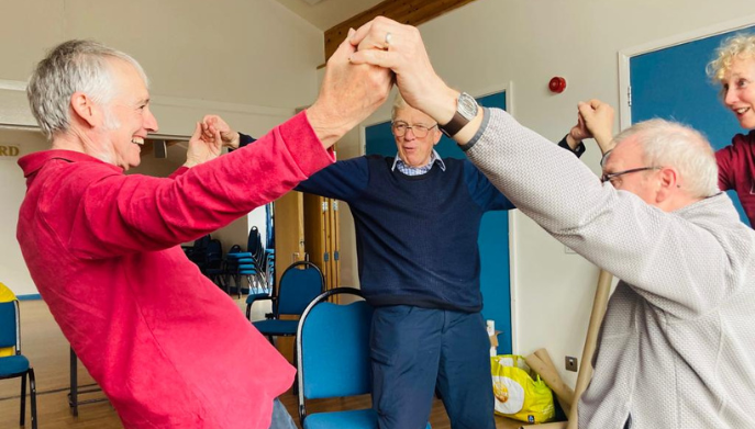 three men standing holding hands in the air