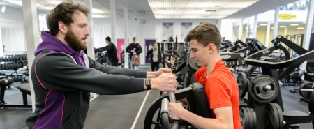 A man coaching a boy in a gym 