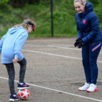 a female coach coaching a girl football