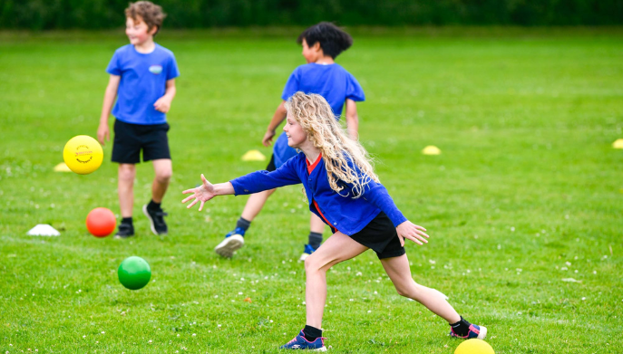 a girl throwing a ball outside