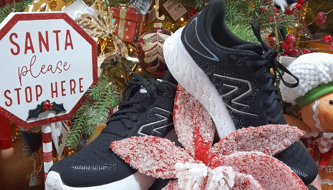 a pair of trainers infront of a decorated Christmas Tree