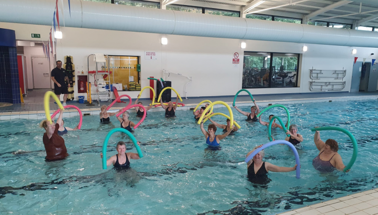 A group of adults taking part in an exercise class in a swimming pool