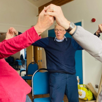 three men standing holding hands in the air