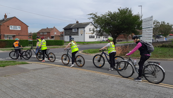 a group of cyclists on a road at a junction