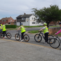 a group of cyclists on a road at a junction