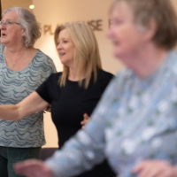 a group of 3 ladies standing exercising